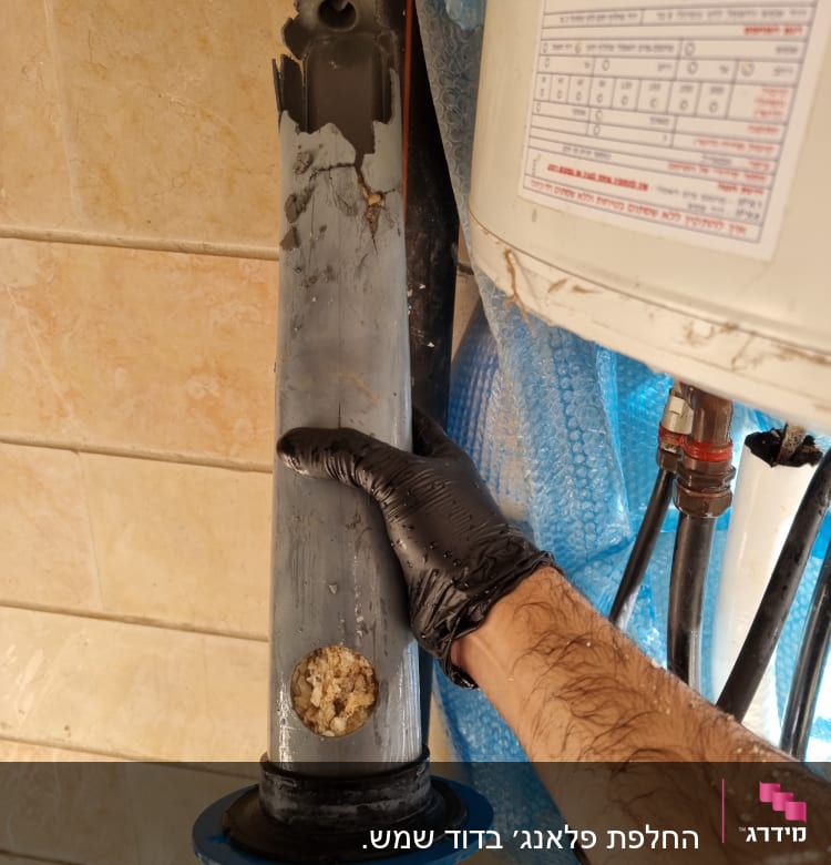 יד עם כפפה מחזיקה חלק מבודד של דוד שמש